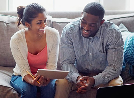 Let Your Home's Equity Work for You - Couple discussing notes happily