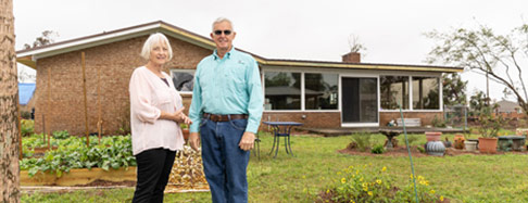 older-couple-in-front-of-house-486x187