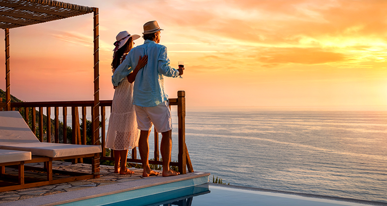 AAA exclusive travel deals let you relax - couple on deck watching the sunset