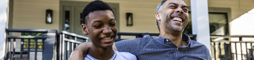 father with AAA life insurance puts arm around son
