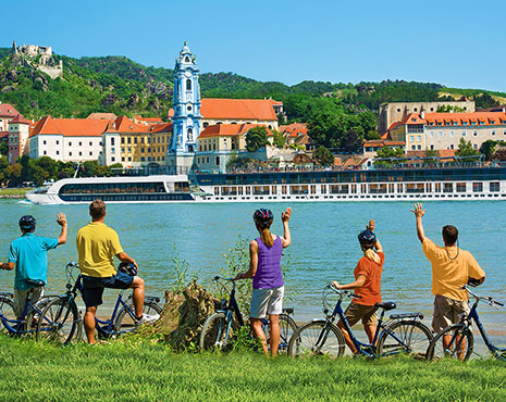 Cyclists waving to river boat