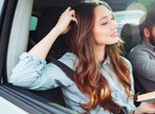 man driving with woman in passenger seat with hand in hair