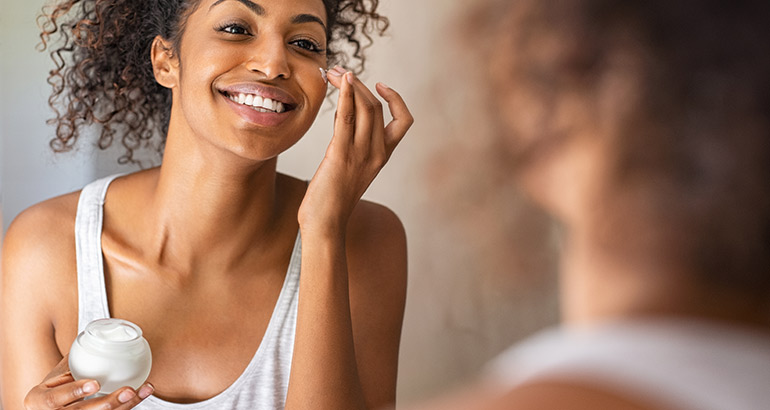 woman putting on moisturizer 