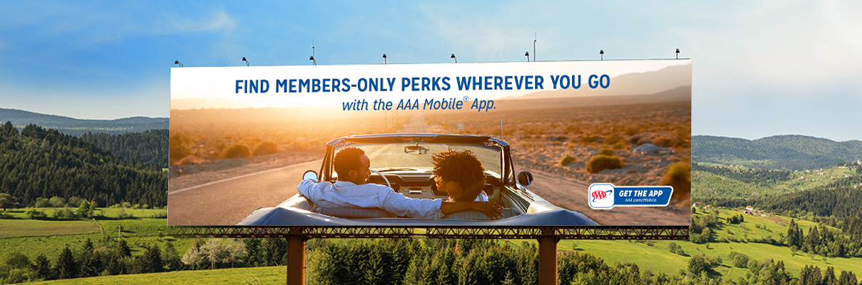 USA Road Trips with AAA Mobile App and billboard with rolling hills behind it