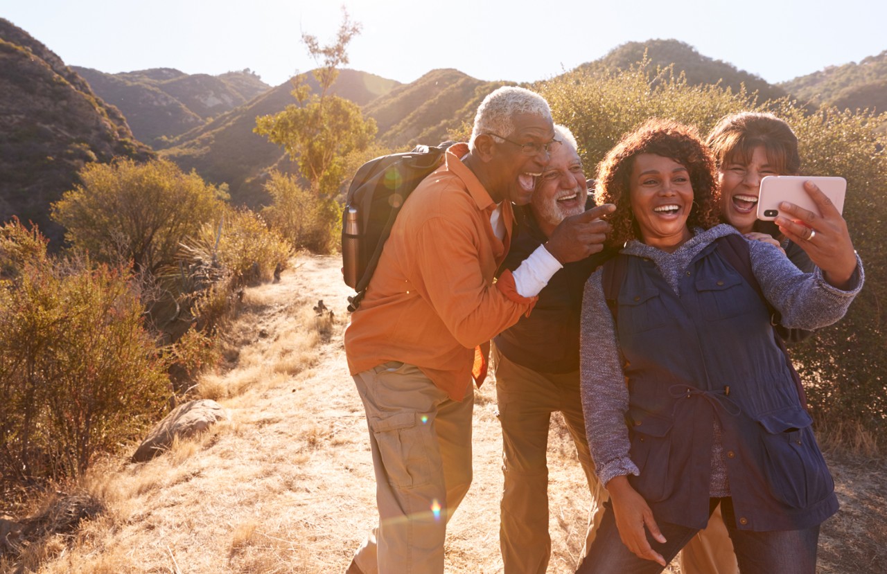 Two couples taking a selfie during hike with joy