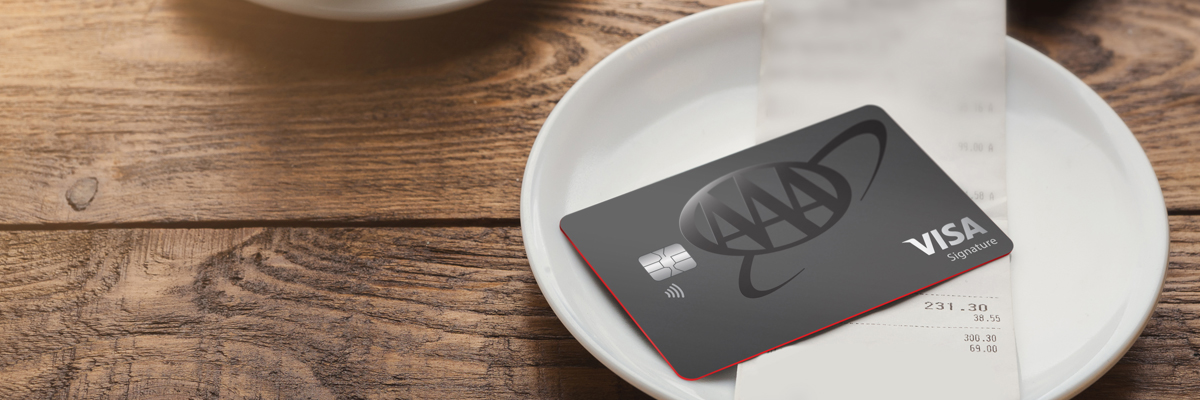 aaa cashback visa signature card laying on top of restaurant check