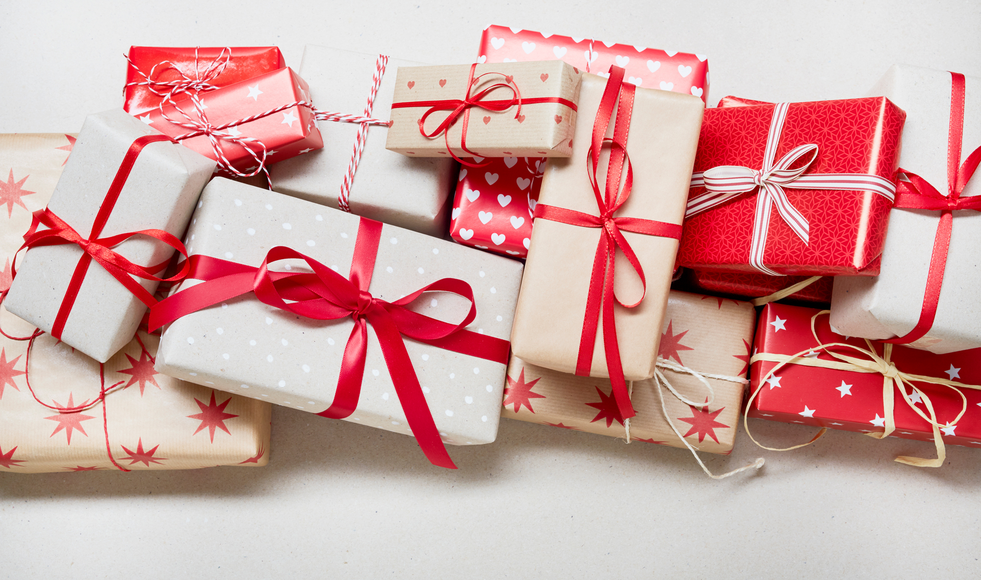 A grouping of holiday presents in white and red wrapping.