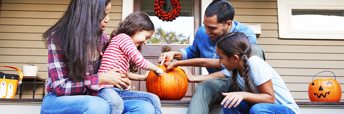 family carving a pumpkin