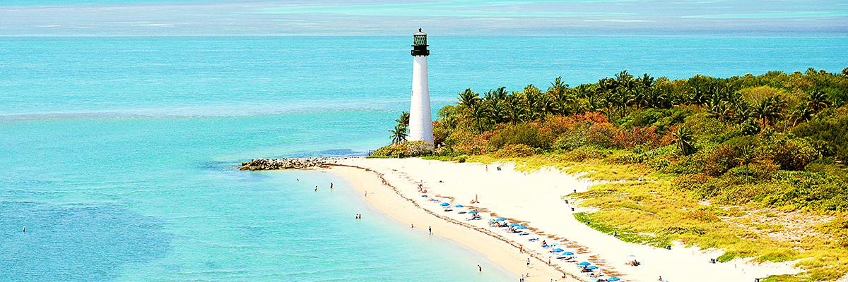 Lighthouse on Florida beach as viewed by a traveler on vacation booked through AAA.