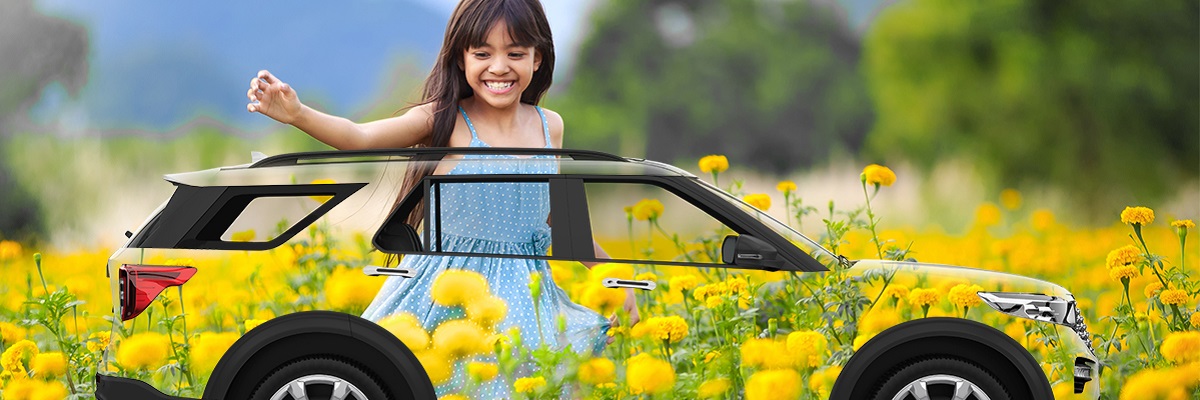 Girl in a field of flowers  with her family on a road trip in Hertz car rental.