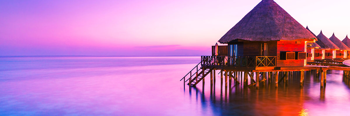 Virtual Travel Event banner with thatched roof vacation hut over water at sunset.