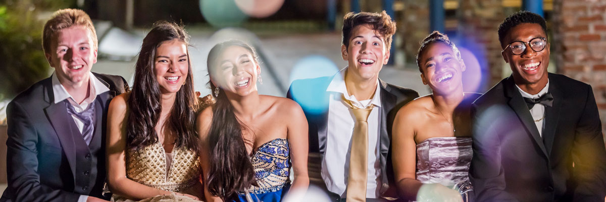 Teen group of six laughing at camera at prom